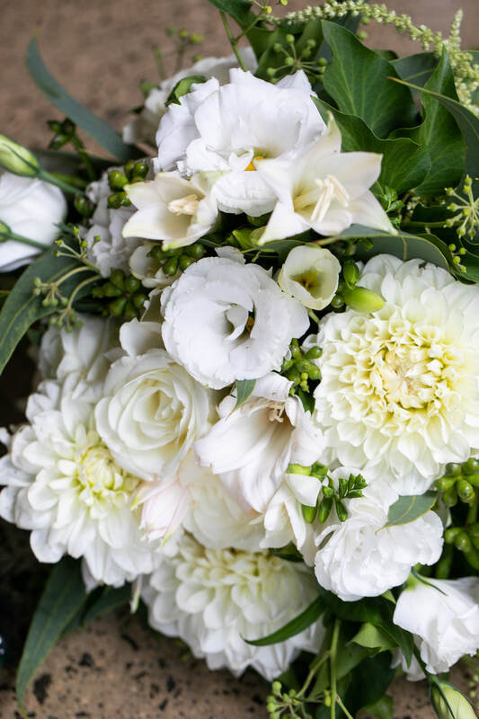 Wedding bouquet of lisianthus, freesia and dahlias in white and green. 