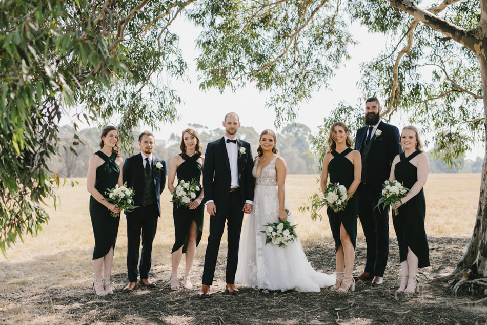Bridal party holding wedding flower bouquets of white and green flowers