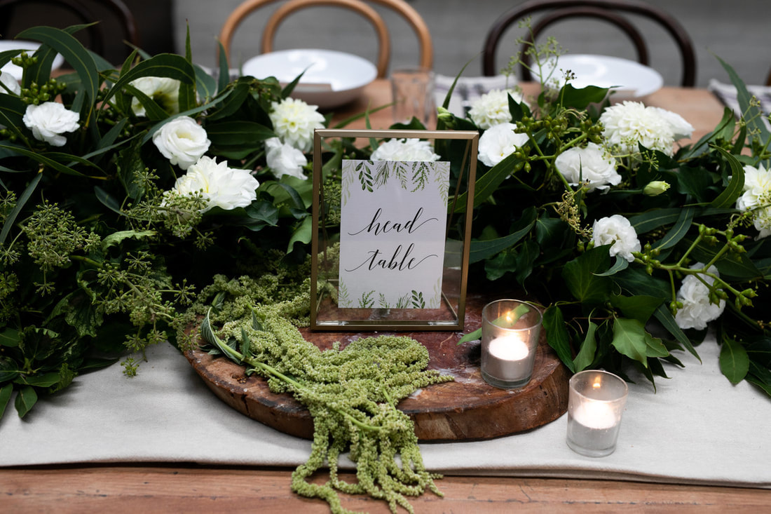 Wedding reception rustic table styling using wood tealights and flower garlands