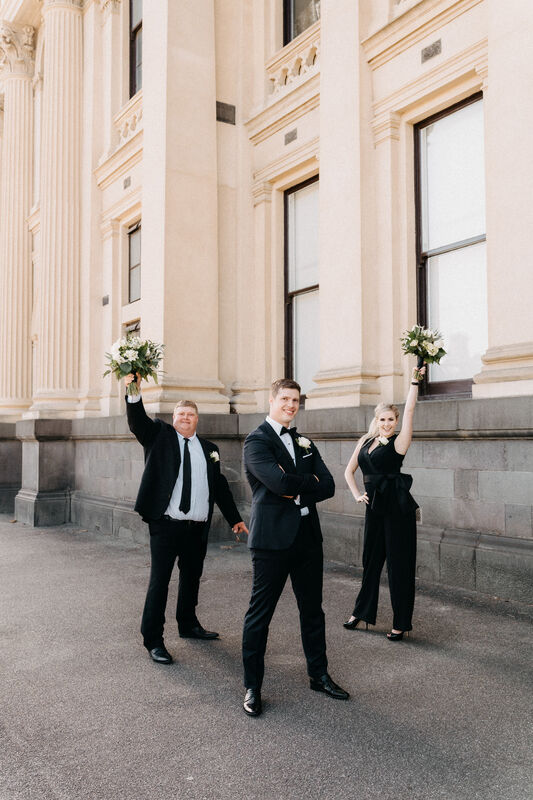 Groom with his best man and best woman wearing black tuxedos