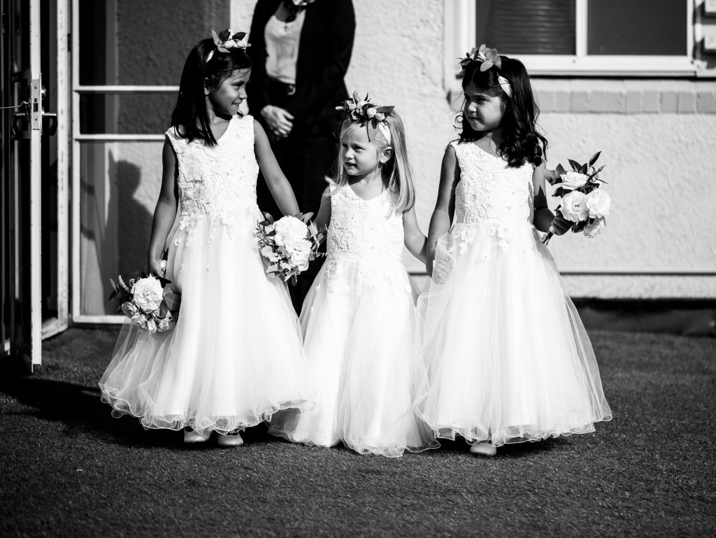 Trio of flower girls wearing eucalyptus flower crowns and holding petite flower bouquets. 
