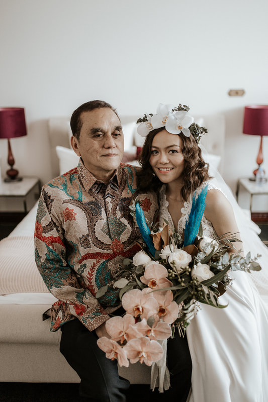 Boho bride and her father with flower bouquet of pampas grass, roses and orchids in sage and cinnamon tones with pops of teal. 