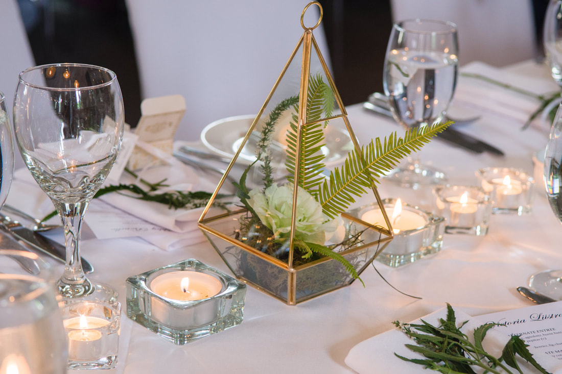 Wedding reception table arrangements, tea lights, gold geo vases and flowers. 