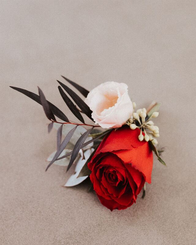 Buttonhole with a rose and buds in red and pink