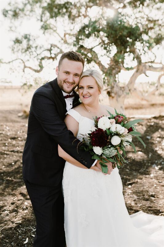 Bride and groom at Russo Estate in Diggers Rest, bride holding bouquet of white and burgundy roses and dahlias with eucalyptus foliage