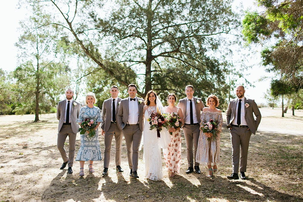 Boho bridal party with mismatched dresses and rustic bouquets. 