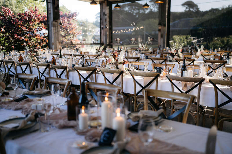 Flowerdale Estate wedding reception long tables decorated with candles, flowers and cheesecloth runner